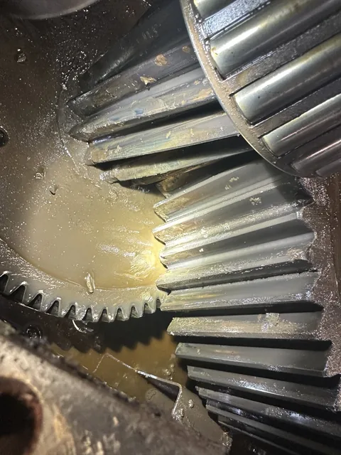 Close-up of meshing bevel gears with lubricant visible in the housing.