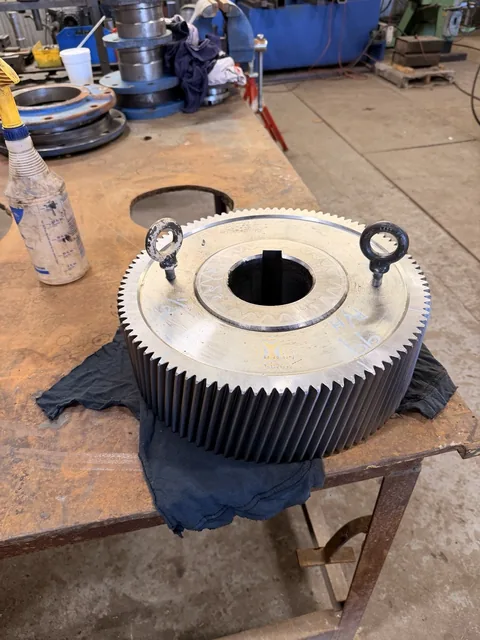 Alternate view of the large helical gear showing its center bore and face.