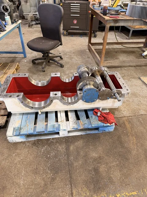 Open lower gearbox housing with red interior and one shaft assembly installed.